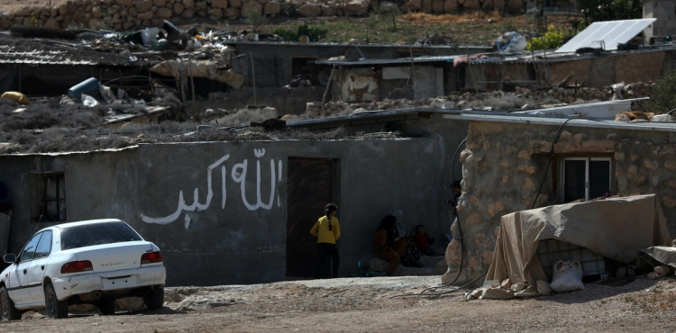 The occupation beats a civilian during the demolition of his house in Masafer Yatta