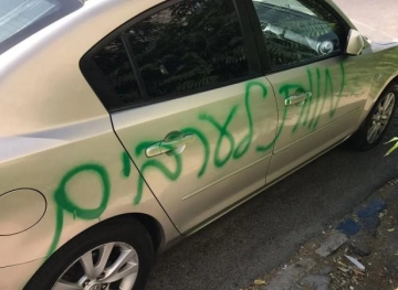 Settlers write slogans and ruin tires of 15 vehicles in Issawiya town