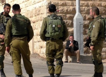 Israeli soldiers destroy a shop near the Tomb of the Patriarchs