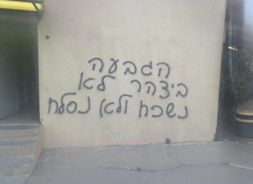 Vehicle damage and slogans in Hebrew at Zarqa bridge