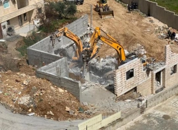 The Israeli occupation forces demolish a house in Beit Ummar village north of Hebron