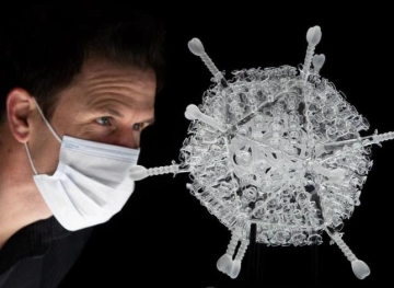 An artist creates a glass sculpture of the AstraZeneca vaccine